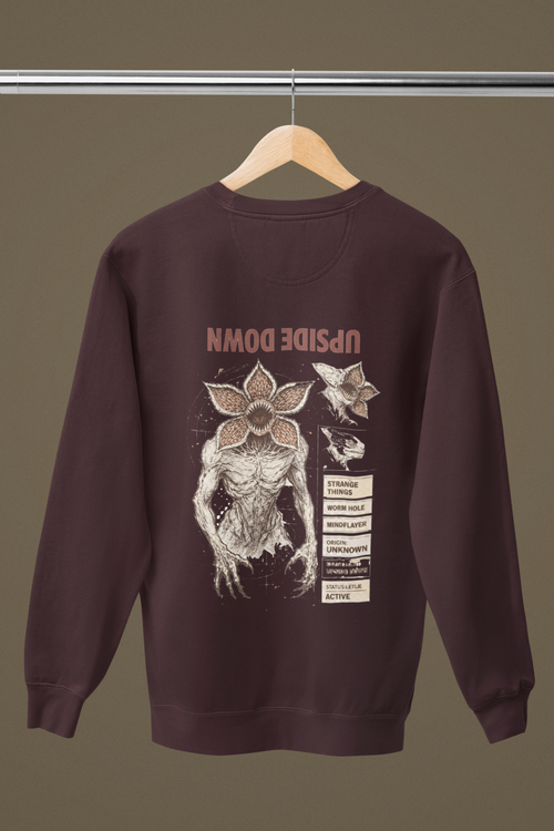 maroon sweatshirt with graphic design on a hanger against a brown background