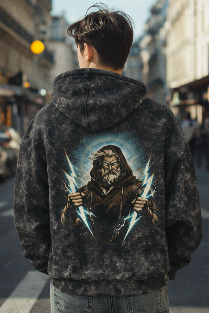 Person wearing a hoodie with a graphic design on the back in an urban street setting